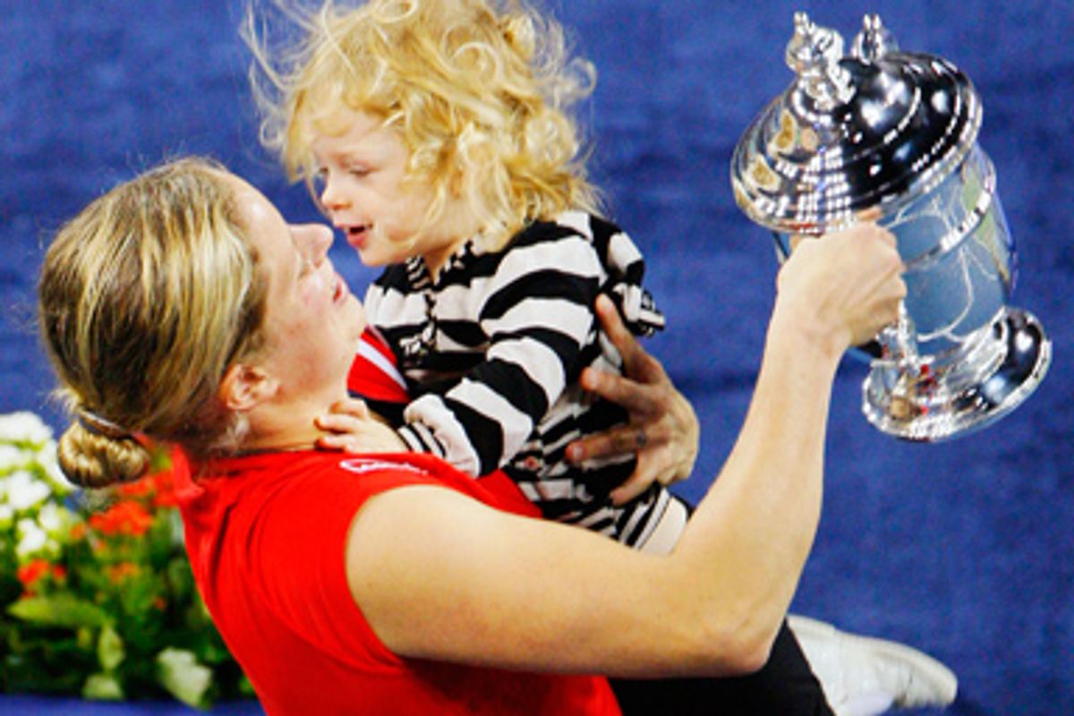 Kim Clijsters of Belgium carries her daughter Jada as she holds the trophy after defeating Caroline Wozniacki of Denmark in the women's singles final match at the U.S. Open tennis tournament in New York, September 13, 2009.