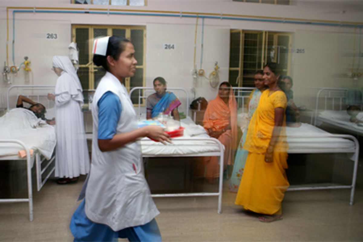 A nurse carries a tray to examine patients in an indoor ward at Nazareth Hospital in Allahabad, India, Sunday, May 11, 2008.