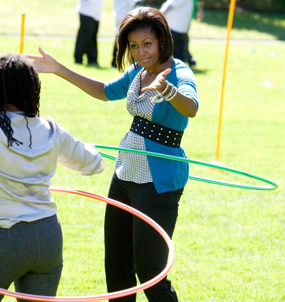 U.S. first lady Michelle Obama tries to hula hoop with children at the White House Healthy Kids Fair on the South Lawn in Washington, October 21, 2009.  REUTERS/Larry Downing (UNITED STATES POLITICS) (Reuters)