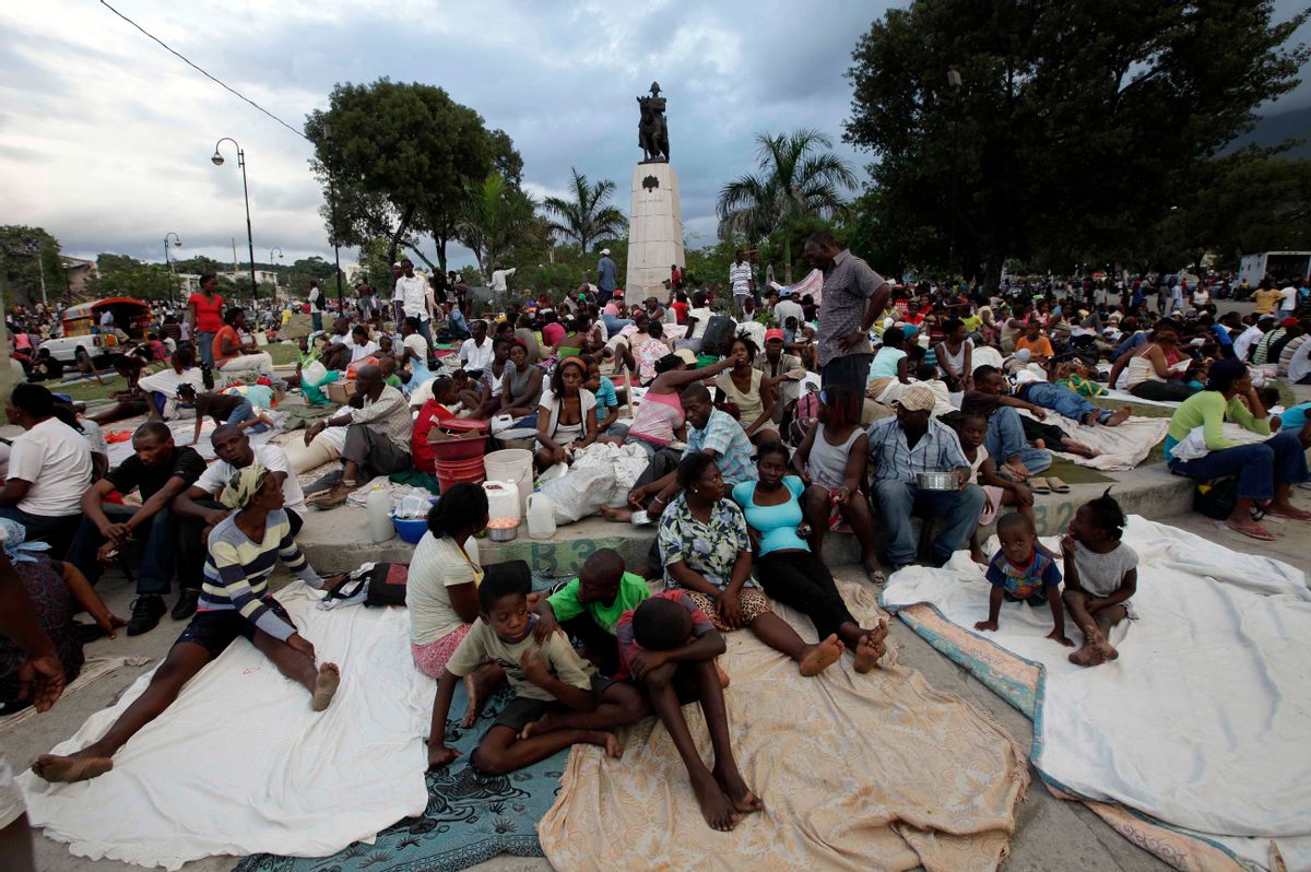 People sit at a park a day after the destructive earthquake in downtown Port-au-Prince, Wednesday, Jan. 13, 2010. The 7.0-magnitude earthquake that hit Haiti on Tuesday flattened the president's palace, the cathedral, hospitals, schools, the main prison and whole neighborhoods. (AP Photo/Gregory Bull)  (Associated Press)