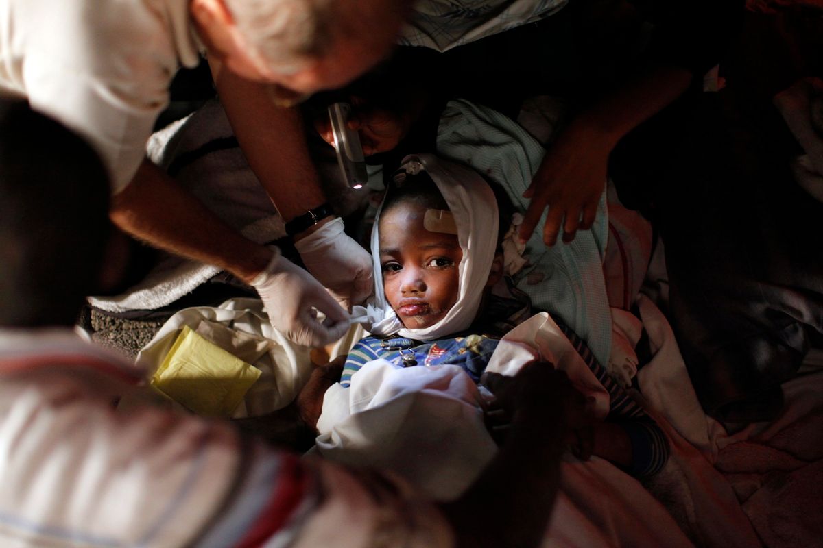 A injured child receives medical treatment after an earthquake in Port-au-Prince January 13, 2010. The  7.0 magnitude quake rocked Haiti, killing possibly thousands of people as it toppled the presidential palace and hillside shanties alike and leaving the poor Caribbean nation appealing for international help. REUTERS/Eduardo Munoz (HAITI tags: - Tags: DISASTER ENVIRONMENT IMAGES OF THE DAY) (Reuters)