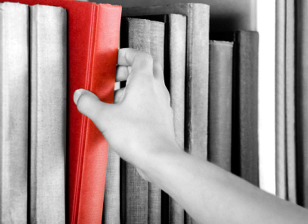 Image of a hand selecting a red book from a bookshelf (Andreas G. Karelias)