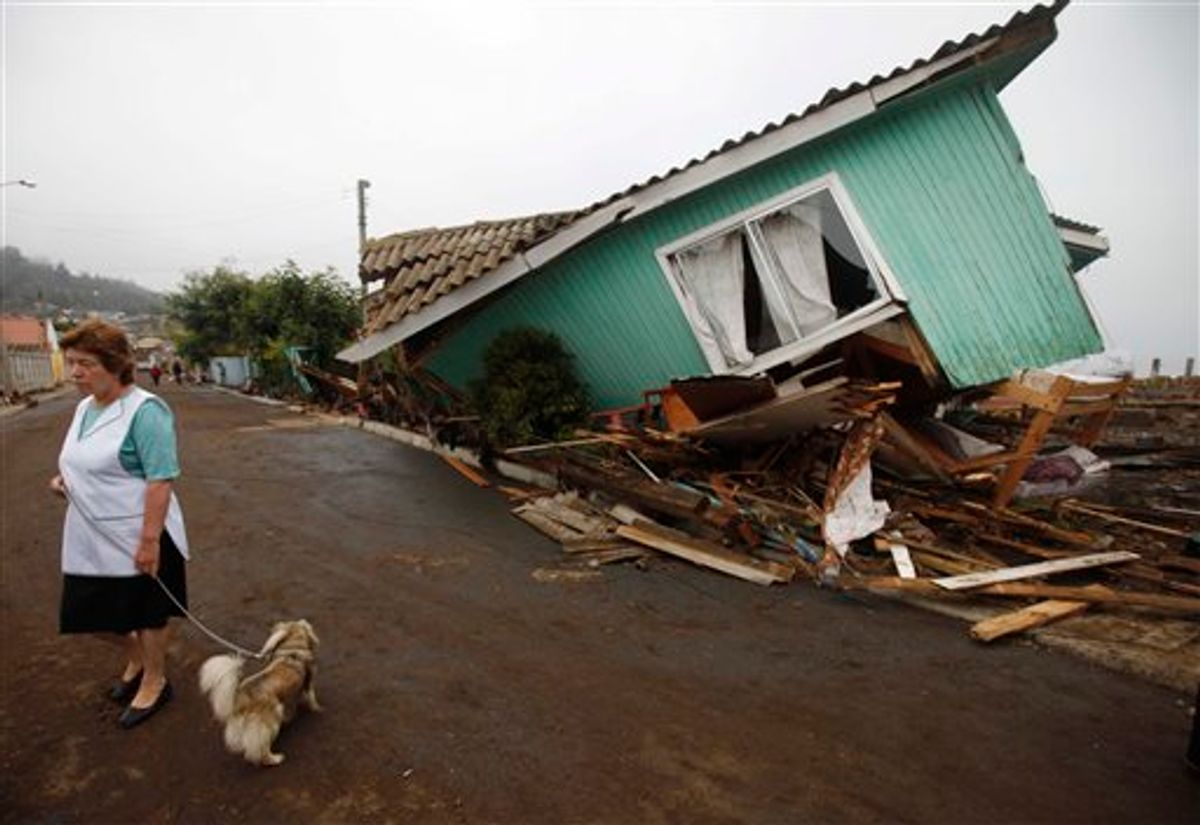 A woman stands in front of a damaged house after an earthquake in Pelluhue, some 322 kms, about 200 miles, southwest of Santiago, Sunday, Feb. 28, 2010. A 8.8-magnitude earthquake hit Chile early Saturday. (AP Photo/Roberto Candia) (AP)