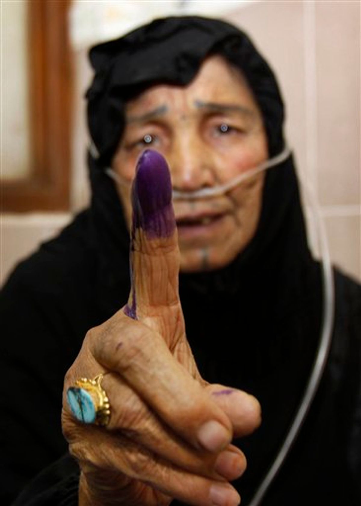 Hospital patient Coka Khudhyer, 72, attached to an oxygen tube, displays her inked finger after casting her vote at Al-Fayha hospital in Basra, Iraq, Thursday, March 4, 2010. Early voting in Iraq for detainees, hospital patients and military and security personnel is taking place Thursday, ahead of the parliamentary elections on Sunday, March 7, 2010. (AP Photo/Nabil al-Jurani) (AP)