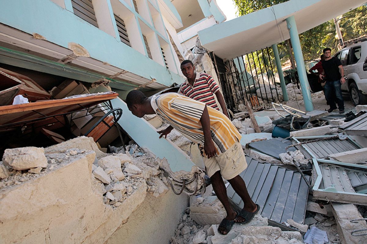 PORT AU PRINCE, HAITI - JANUARY 15:  Haitians as they pass by peek into the rubble of the College of St. Pierre that collapsed during the earthquake this week on January 15, 2010 in Port-au-Prince, Haiti.  Haiti is trying to recover from a powerful 7.0-strong earthquake that struck and devastated the nation on January 12.  (Photo by Chris Hondros/Getty Images)  (Chris Hondros)