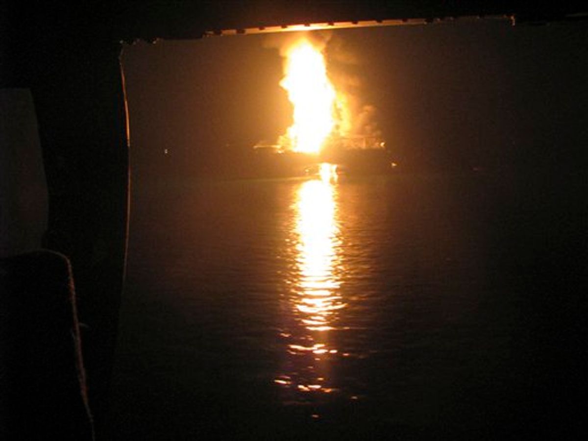 In this Wednesday April 21, 2010 photo released by the U.S. Coast Guard, a fire aboard the mobile offshore drilling unit Deepwater Horizon burns 52-miles southeast of Venice, La. Helicopters, ships and an airplane searched waters off Louisiana's coast Wednesday for missing workers after an explosion and fire that left an offshore drilling platform tilting in the Gulf of Mexico. (AP Photo/U.S. Coast Guard, Petty Officer 2nd Class Scott Lloyd) (AP)