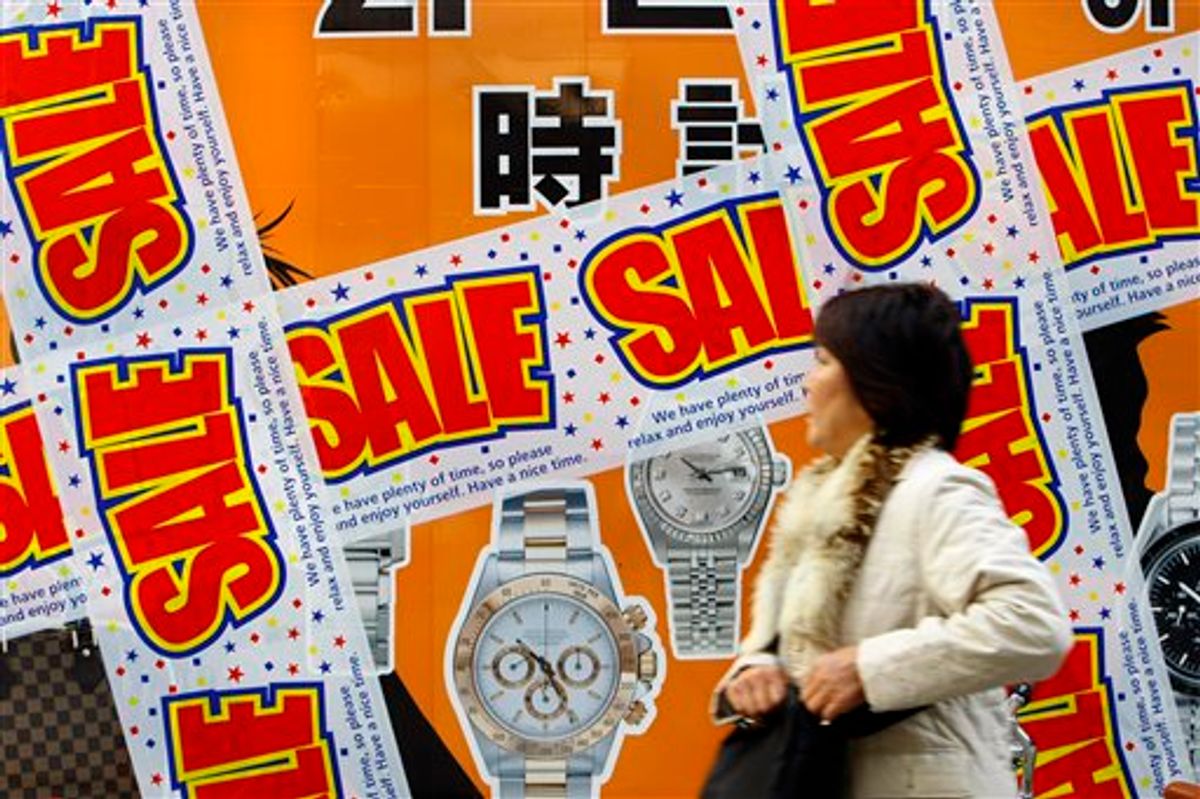 FILE - In this Nov. 20, 2009, file photo, a woman walks by a shop with sale signs in Tokyo, Japan.  Japan says consumer prices kept falling in February as deflation strengthened its grip on the world's second biggest economy. The core consumer price index, which excludes fresh food, retreated 1.2 percent from a year earlier, the government said Friday March 26, 2010. (AP Photo/Shizuo Kambayashi) (AP)
