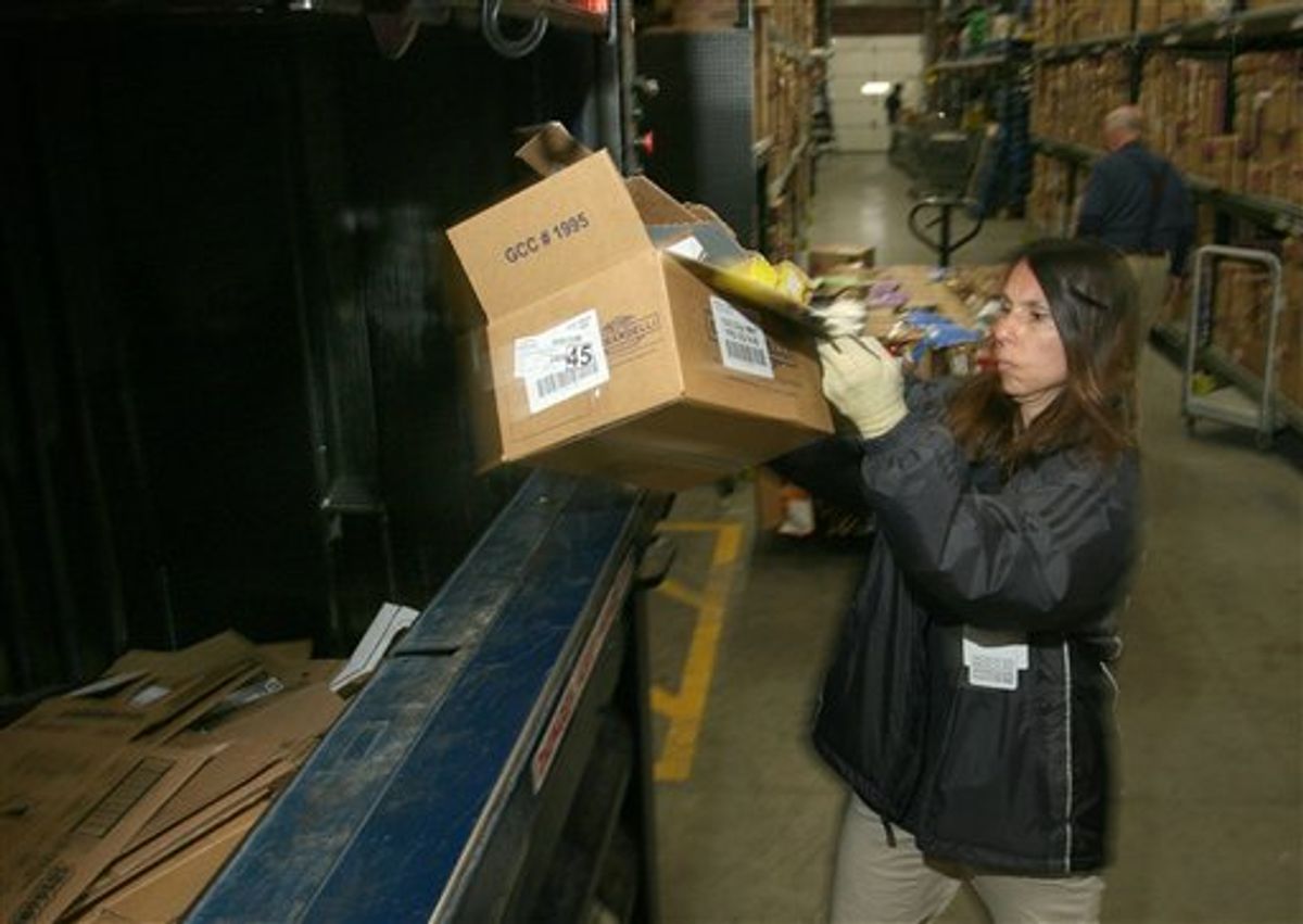 In this April 4, 2010 photo, Wal-Mart worker Julie Buczek throws used packaging boxes into a compressor for recycling at a Cincinnati area Walmart. Retailer Wal-Mart Stores Inc. is urging its suppliers to reduce 20 million metric tons of greenhouse gas emissions by the end of 2015, on top of its own moves to build more energy-efficient stores, using more alternative fuels for its truck fleet, and reduce packaging.(AP Photo/Tom Uhlman) (AP)