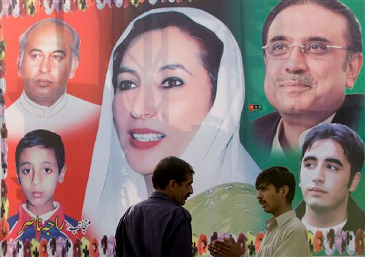 Pakistani men chat at each other in front of a poster of former Prime Minister Benazir Bhutto, center, in Rawalpindi, Pakistan, Friday, April 16, 2010. A new U.N. report that blames Pakistan's security establishment for failing to stop the assassination of Bhutto paves the way for a "proper police investigation" into her killing, aides to her widower, said Friday. (AP Photo/Vincent Thian) (AP)