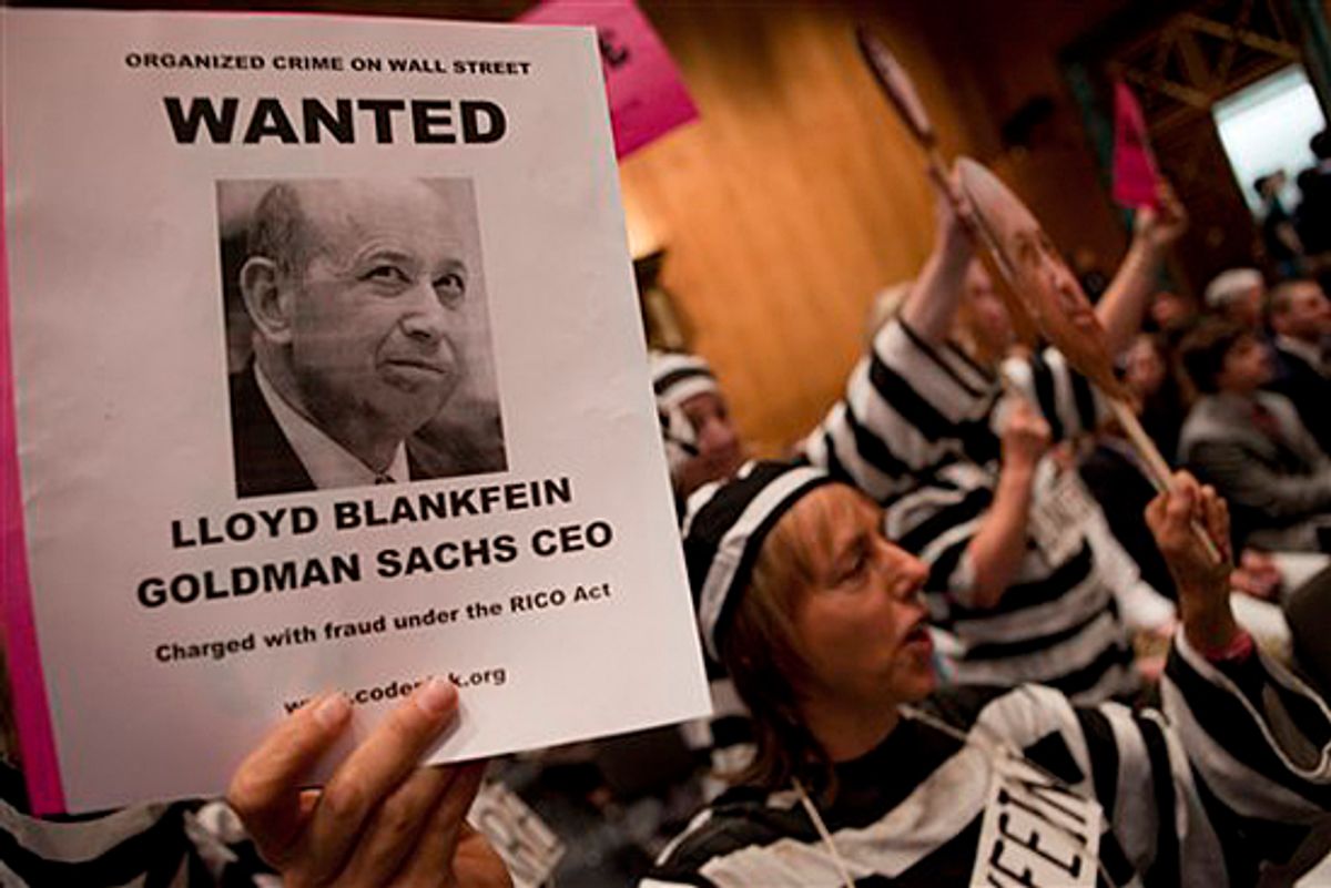 Protestors hold up a photo of Goldman Sachs Chief Executive Officer Lloyd Blankfein on Capitol Hill in Washington, Tuesday, April 27, 2010, during the Senate Investigations subcommittee hearing. (AP Photo/Evan Vucci)      (Evan Vucci)