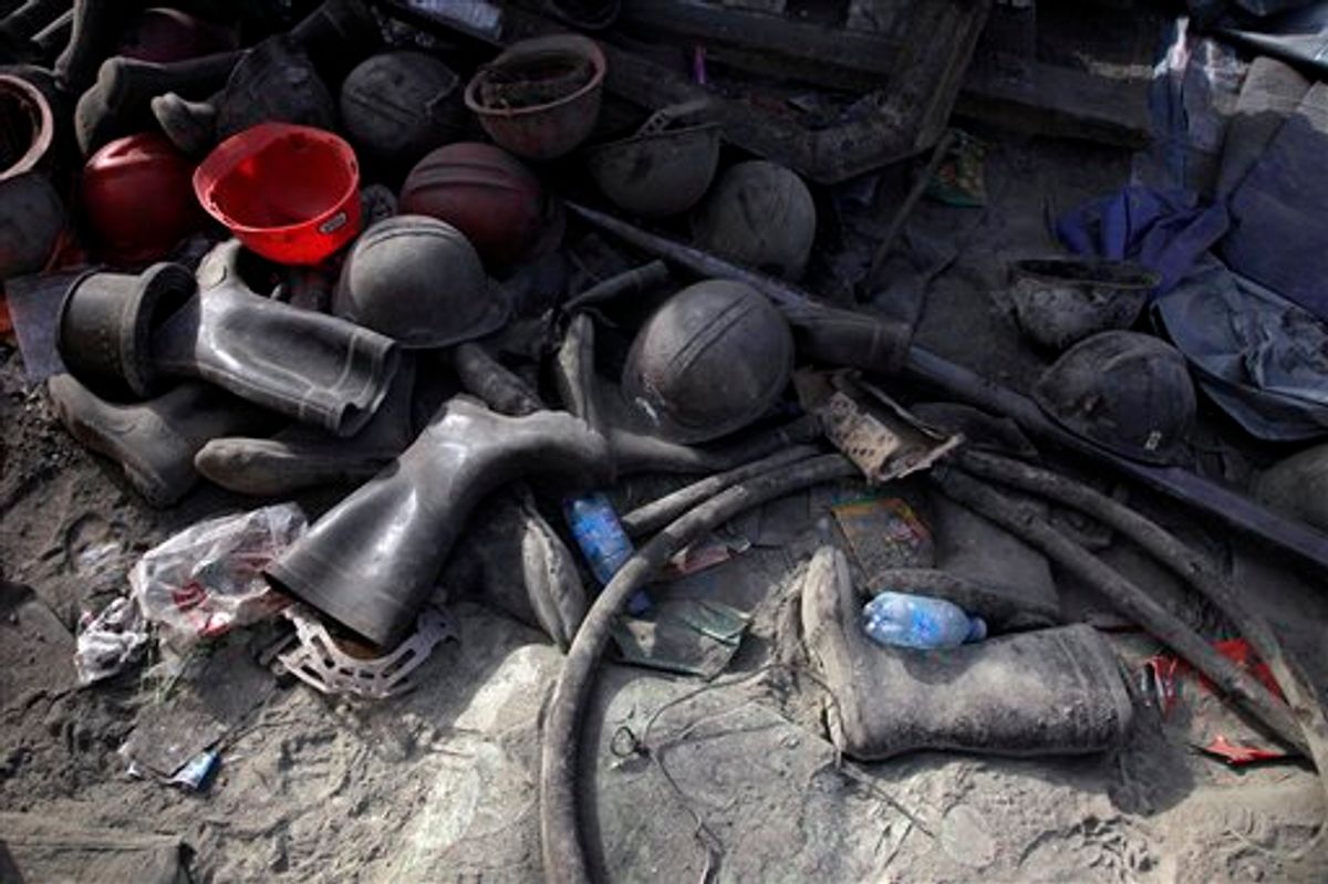 Helmets and boots pile up in the dust outside the shaft to the Wangjialing Coal Mine in Xiangning county in north China's Shanxi province, Sunday, April 4, 2010. Search and rescue continue almost a week after water flooded a mine, trapping 153 miners. (AP Photo/Ng Han Guan) (AP)