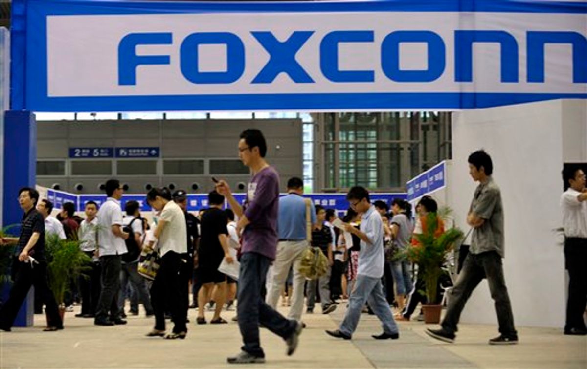 In this photo taken on May 22, 2010, visitors to a job fair walk past the Foxconn recruitment area in Shenzhen in south China's Guangdong province.   (AP)
