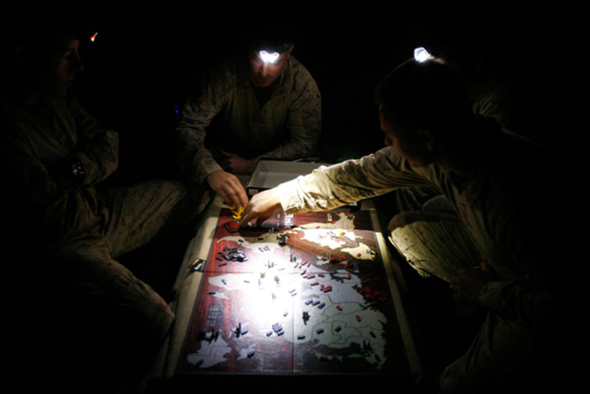 U.S. Marines from Kilo company, 3rd Battalion 6th Marines play a round of the "Risk" boardgame by the light of their flashlights in COP Reilly base in Marjah district, Helmand province, March 24, 2010. REUTERS/Asmaa Waguih  (AFGHANISTAN - Tags: MILITARY POLITICS IMAGES OF THE DAY)  (Â© Asmaa Waguih / Reuters)