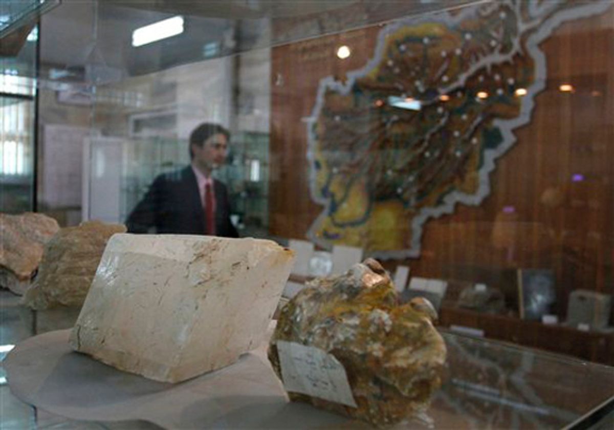 An Afghan journalist walks by precious stones on display as he attends a press conference of Afghan Minister of Mines Wahidullah Shahrani in Kabul, Afghanistan on Thursday, June 17, 2010. An Afghan mining official says the untapped minerals in the war-torn country are worth at least $3 trillion, triple a U.S. estimate. (AP Photo/Musadeq Sadeq) (Musadeq Sadeq)