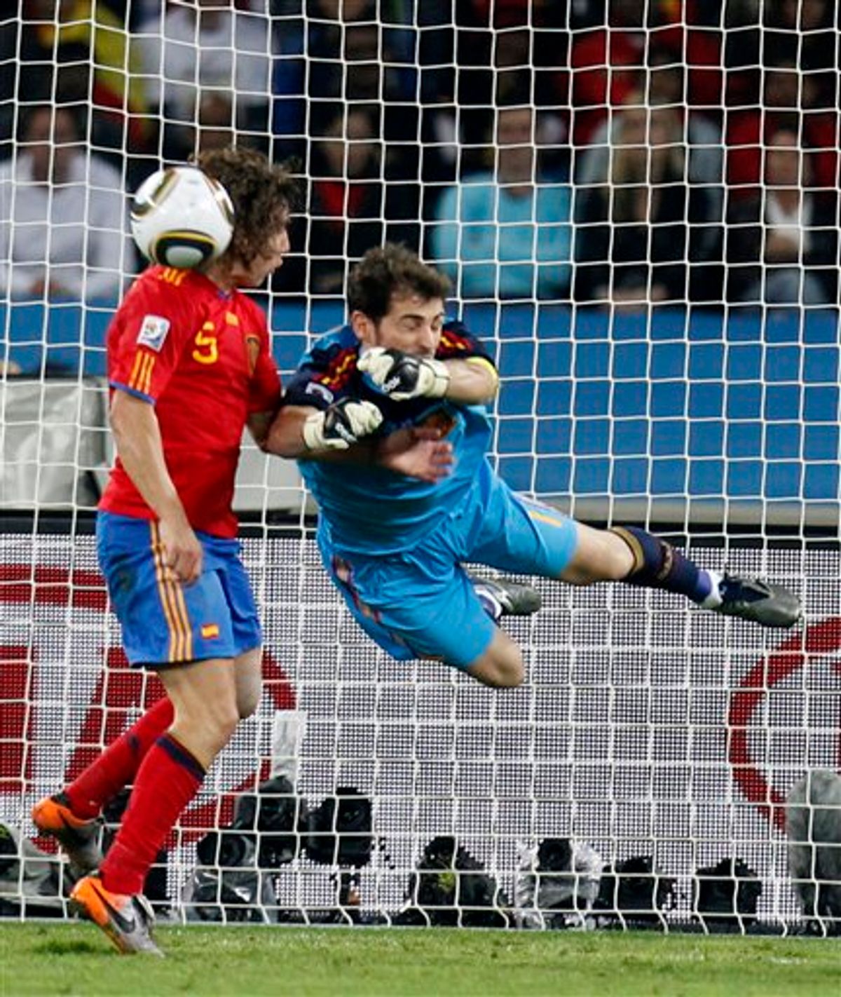 Spain goalkeeper Iker Casillas, right, clears the ball next to Spain's Carles Puyol, left, during the World Cup semifinal soccer match between  Germany and Spain at the stadium in Durban, South Africa, Wednesday, July 7, 2010.  (AP Photo/Luca Bruno)   (AP)