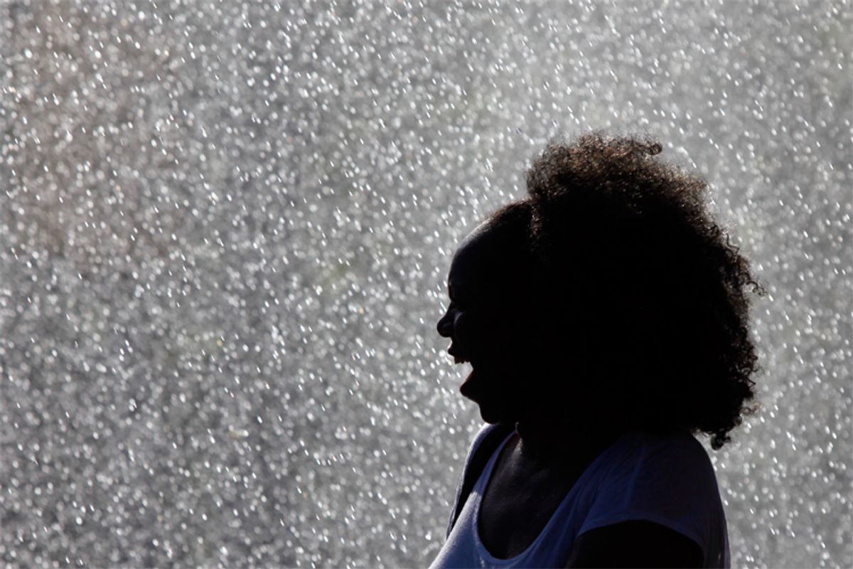 An unidentified woman cools off from the heat of the day under water sprayed from a fire engine in Philadelphia on Sunday.