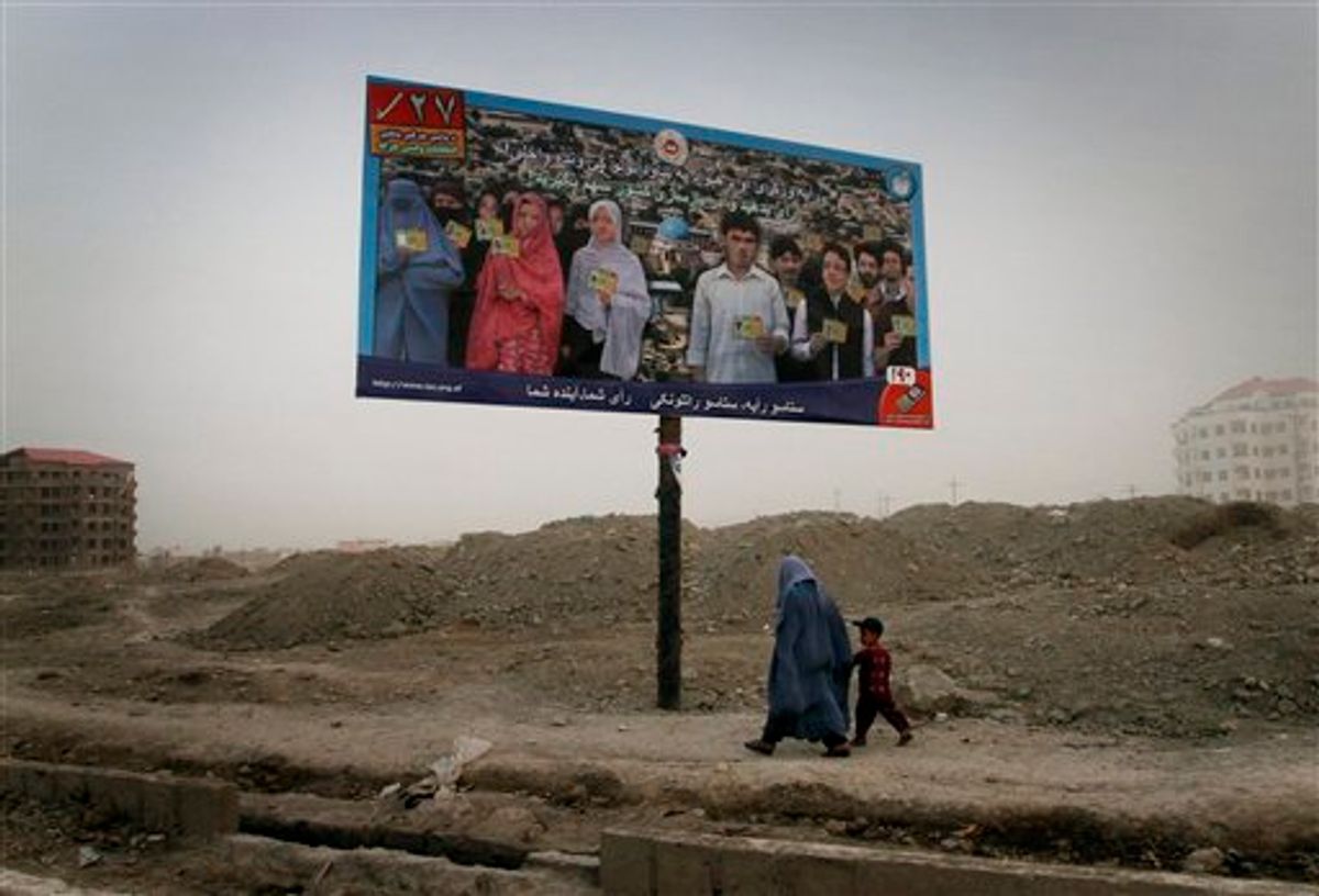 In this Monday, Aug. 23, 2010 photo, an Afghan woman walks with her son under an election billboard asking people to vote for upcoming parliamentarian election in Kabul, Afghanistan. Afghans will go to the polls for parliamentary elections in September. After a fraud-ridden presidential election last year that nearly undermined President Hamid Karzai's legitimacy and international support, the Sept. 18 parliamentary ballot is being watched closely as a test of whether the Afghan government is serious about reform. (AP Photo/Musadeq Sadeq) (AP)