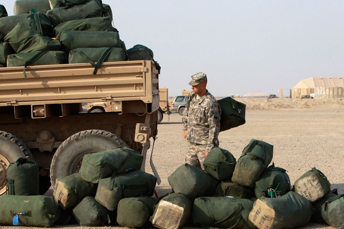 A U.S. soldier from the 1st Battalion, 116th Infantry Regiment, waits to load his bag onto a military vehicle carrying other bags as he prepares to leave for Kuwait from Tallil Air Base near Nassiriya, Iraq, on August 15.