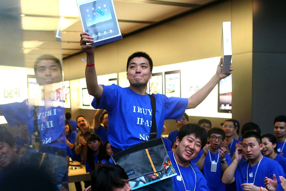 Customer Han Ziwen holds up his iPads while being carried out by store employees at the Apple flagship store in Beijing    