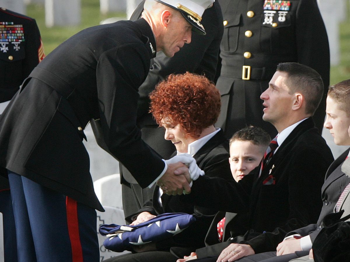Marine Col. Gregory Boyle, left, pays his respects to the parents of Pvt. Heath D. Warner, of Canton, Ohio, Melissa and Scott Warner, after handing them the U.S. flag that was draped his casket, during funeral service at Arlington National Cemetery, in Arlington, Va., Tuesday, Dec. 12, 2006. 