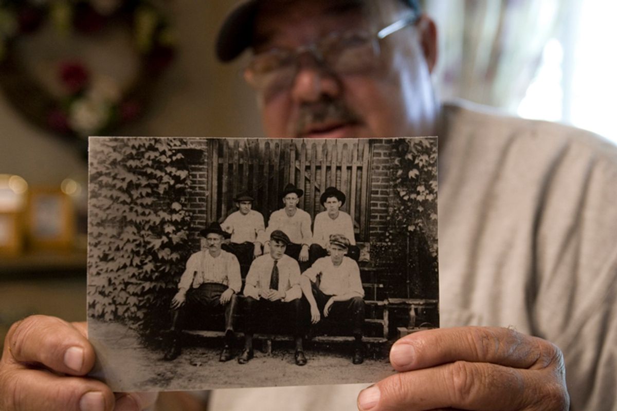 James D. Cannon holds a family photo that shows his grandfather, Claude Cannon, seated in the front row far left, who was killed in the Chiquola Mill shooting in 1934 were 7 people died and over 34 people injured over labor unions that the mill didn't want.(AP Photo/Mary Ann Chastain) (Mary Ann Chastain)