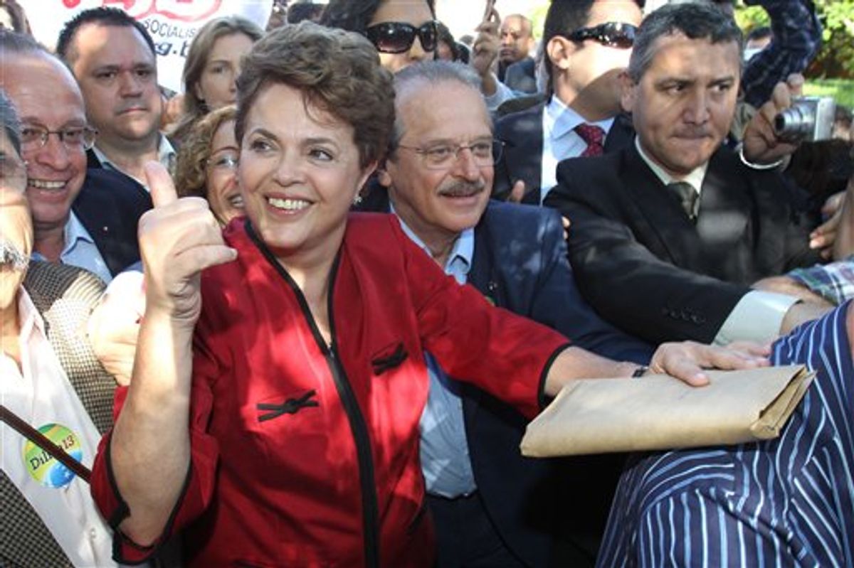 Dilma Rousseff, presidential candidate for the governing Workers Party, greets supporters as he leaves a polling station after voting in Brazil's presidential election runoff in Porto Alegre, Brazil, Sunday Oct. 31, 2010.  (AP Photo/Nabor Goulart) (AP)