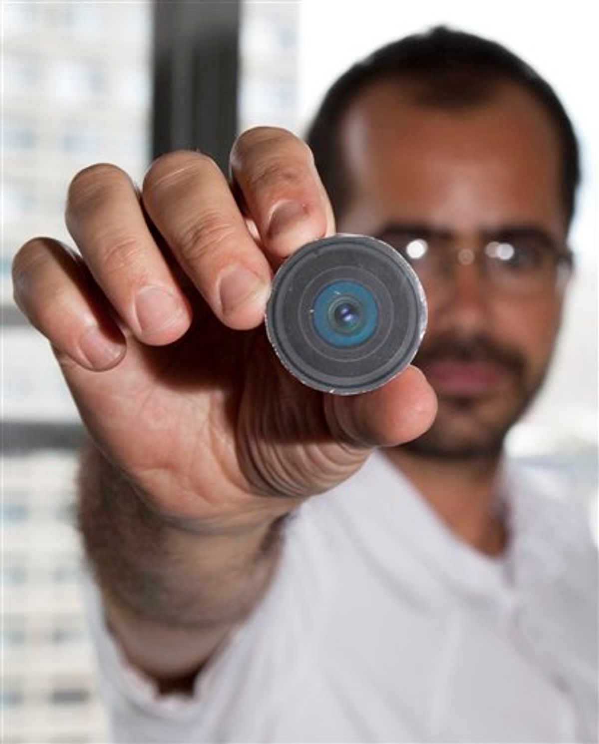 This Aug. 24, 2010 photo provided by New York University arts professor Wafaa Bilal, shows Bilal holding the prototype of a digital camera that he had implanted in the back of his head, in New York.  Bilal, a visual artist widely recognized for his interactive and performance pieces, has undergone surgery to implant a tiny camera in the back of his head for an artwork commissioned by a new museum in Doha, Qatar. Titled "The 3rd I," it is one of 23 contemporary works commissioned for the opening of Mathaf: Arab Museum of Modern Art on Dec. 30, 2010. (AP Photo/Wafaa Bila, Bard Farwell) NO SALES (AP)