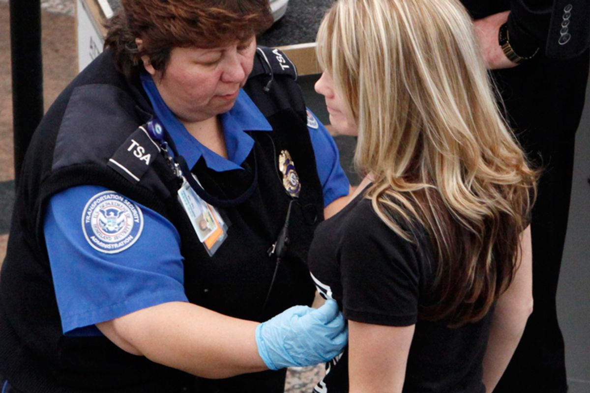 A TSA worker pats down a passenger at Denver International Airport on Tuesday.