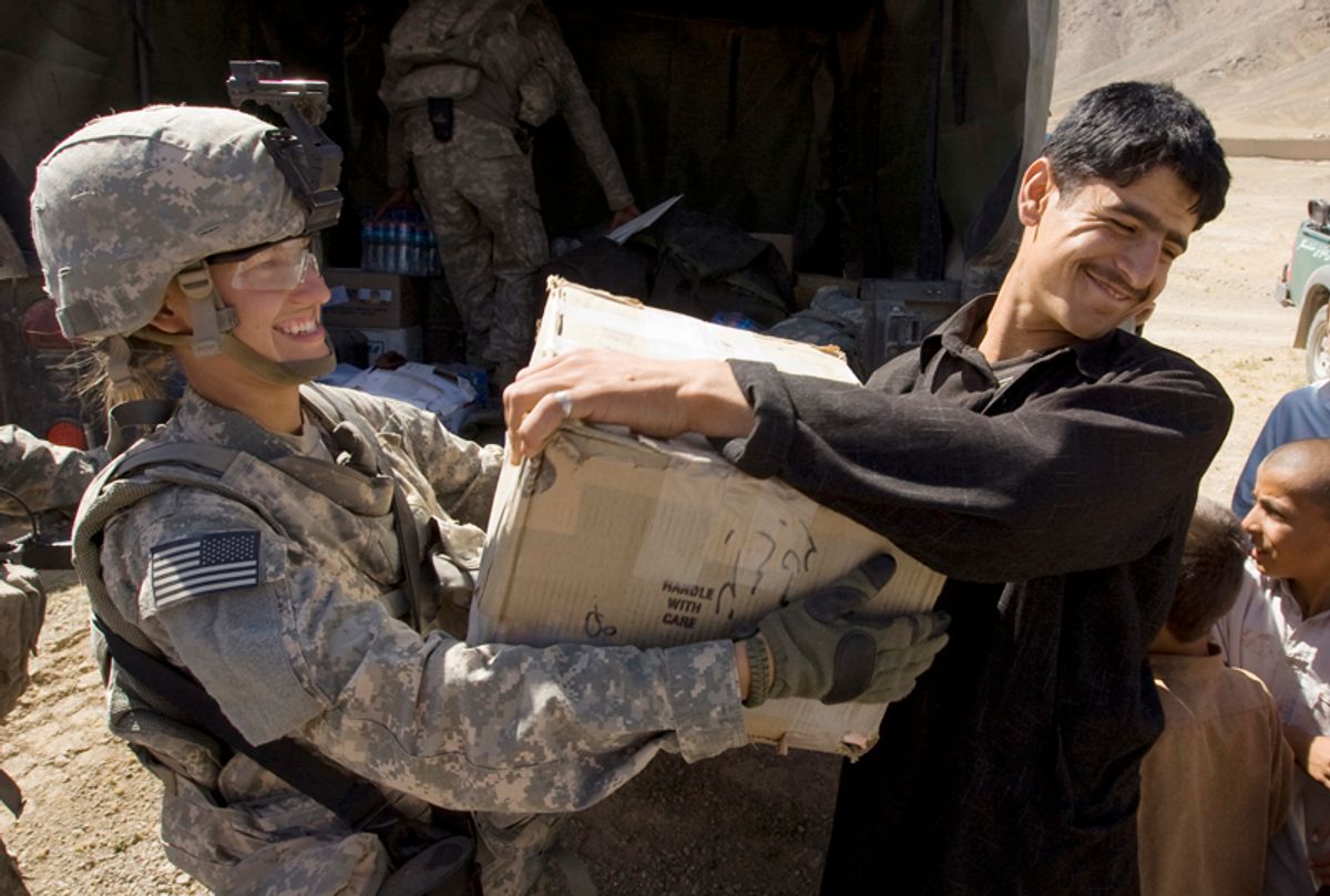 U.S. Private Charlie Johnson of 3rd Brigade Special Troops Battalion, 10th Mountain Division gives a box to an Afghan man during a hospital supply delivery in the village of Dah-e-Naw in Logar Province of Afghanistan July 23, 2009.   REUTERS/Shamil Zhumatov (AFGHANISTAN CONFLICT MILITARY POLITICS SOCIETY)  (?? Shamil Zhumatov / Reuters)
