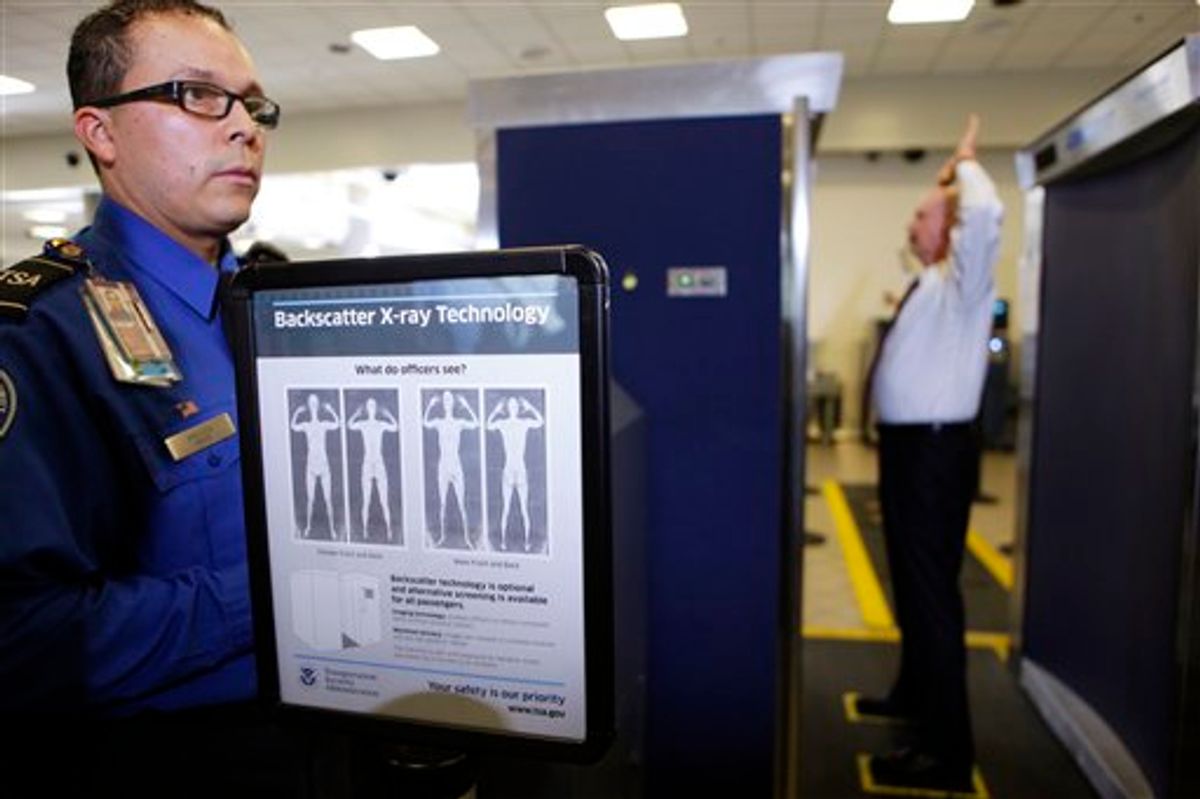 Transportation Security Administration screener Marlon Tejada, left, watches as Randy Parsons, TSA acting Federal Security Director, right, goes through a full body X-ray scanner for a security screening Monday, Nov. 22, 2010, at the Los Angeles International airport. (AP Photo/Damian Dovarganes) (AP)