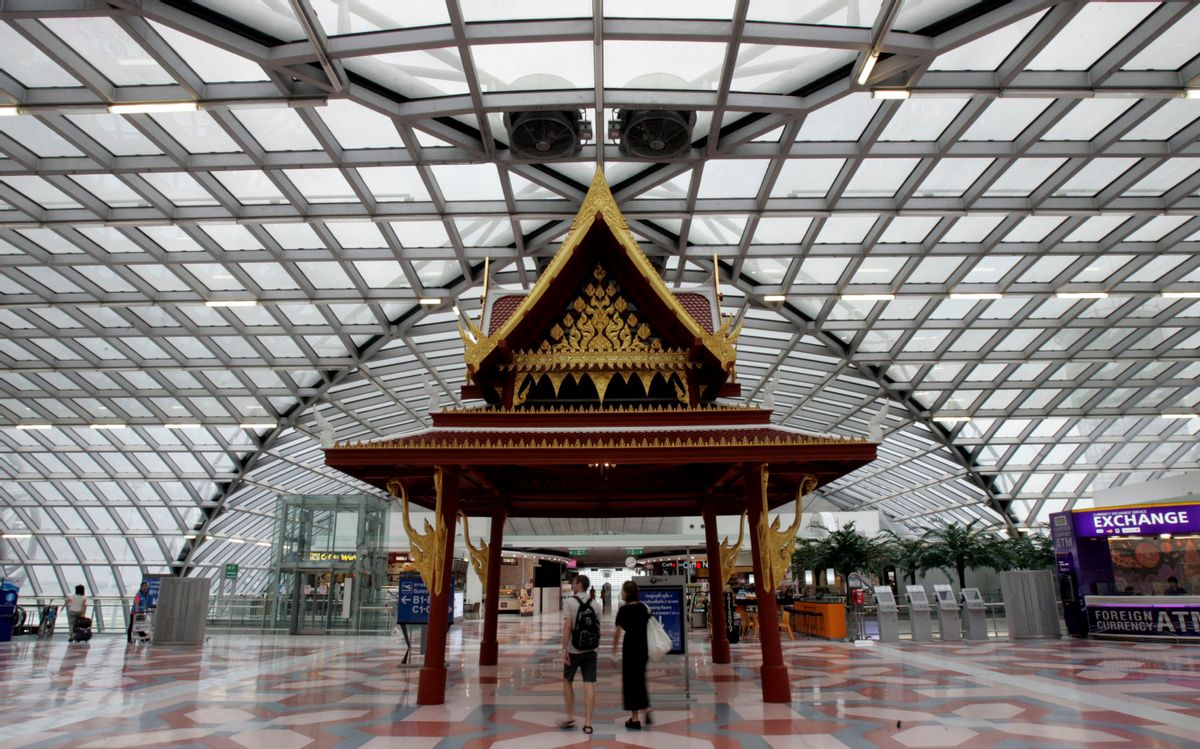 In this photo taken Tuesday, Sept. 8, 2009, two tourists stroll past a Thai-styled pavillian at departure hall at Suvarnabhumi International Airport in Bangkok, Thailand. The Tourism Authority of Thailand is offering five couples fully paid trips to the country's most popular cities and beaches. In return, they will be asked to blog, chat and tweet about their holiday in a bid to win a grand prize of $10,000, a BlackBerry and a video camera. Thailand's tourism industry is facing its worst crisis in years, with foreign arrivals down 15 percent so far this year because of political upheaval and the global recession. (AP Photo/Apichart Weerawong)  (Apichart Weerawong)
