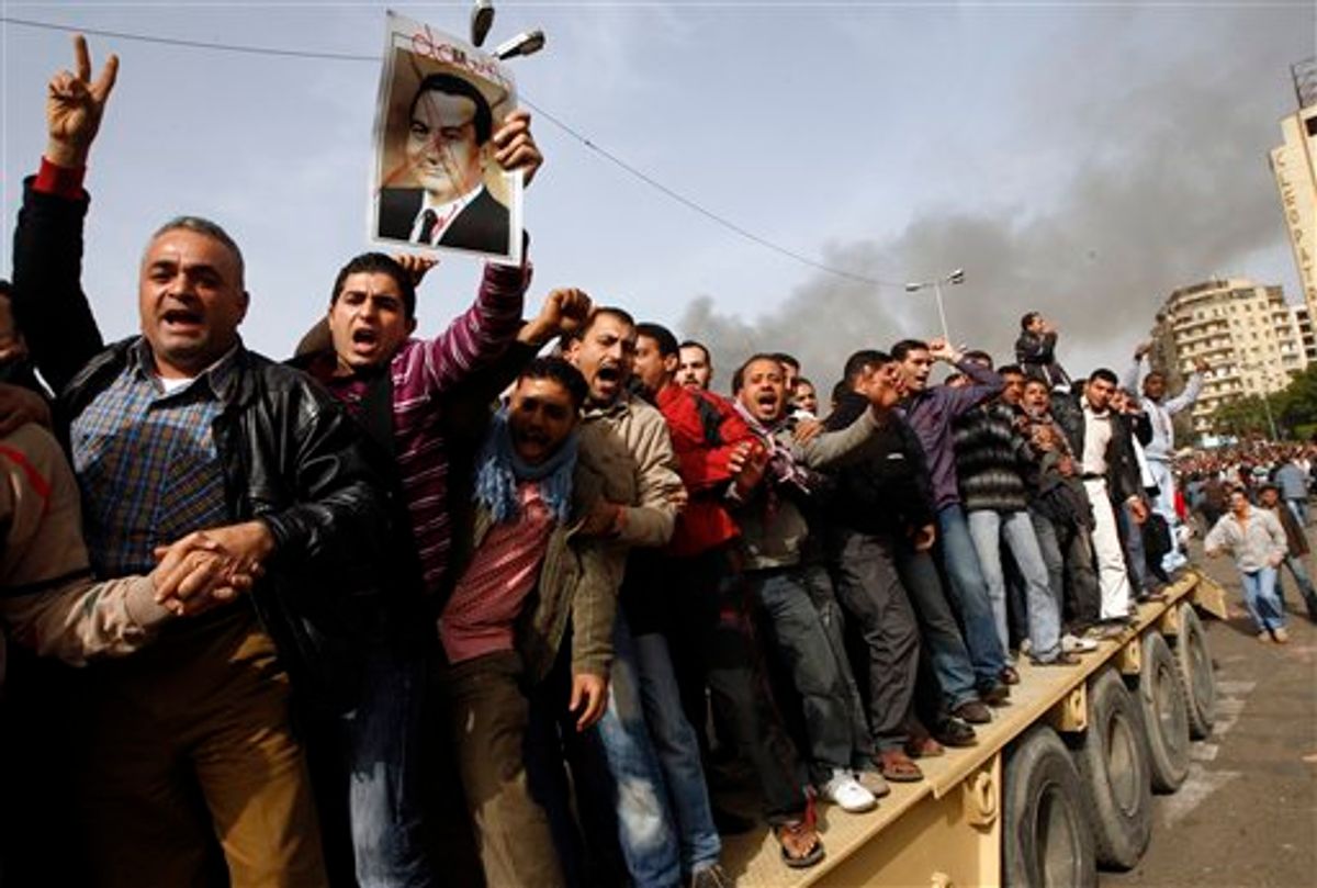 Egyptian anti-government activists, one of them holding a crossed-out portrait of Egyptian President Hosni Mubarak, chant slogans as they protest in downtown Cairo, Egypt, Saturday, Jan. 29, 2011. (AP Photo/Khalil Hamra) (AP)
