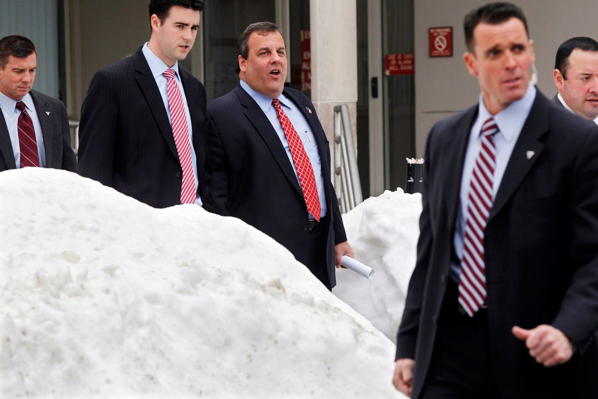 New Jersey Gov. Chris Christie, third from left, walks past piles of snow with staff and security as he leaves an event Friday, Dec. 31, 2010, in Freehold, N.J., where he talked about last weekend's snow storm. Christie left for Florida and a family vacation at Disney World last Sunday. (AP Photo/Mel Evans) (Mel Evans)