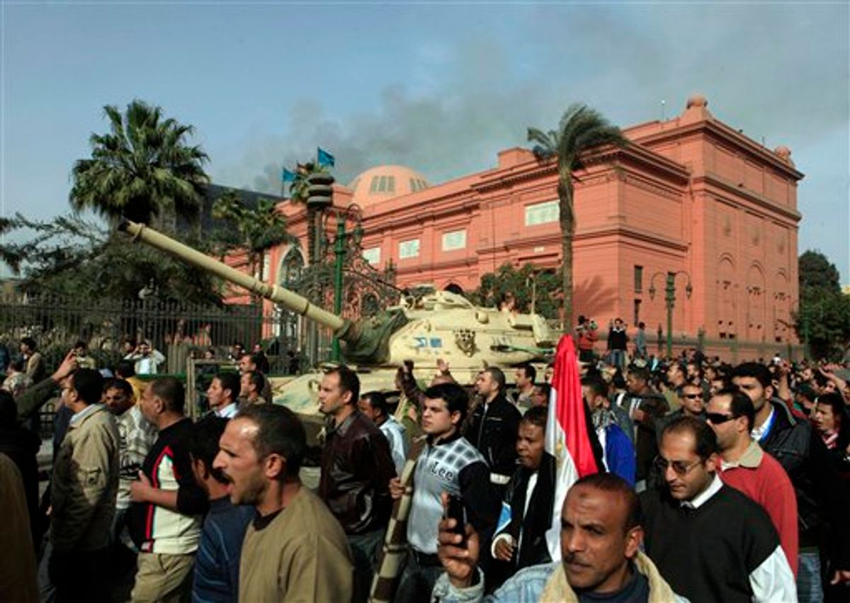 Egyptian protesters march in front of an army tank, past the Egyptian Museum in background, Cairo, Egypt, Saturday, Jan. 29, 2011. Hundreds of anti-government protesters have returned to Cairo's central Tahrir Square, chanting slogans against Hosni Mubarak just hours after the Egyptian president fired his Cabinet but refused to step down. (AP Photo/Amr Nabil) (AP)
