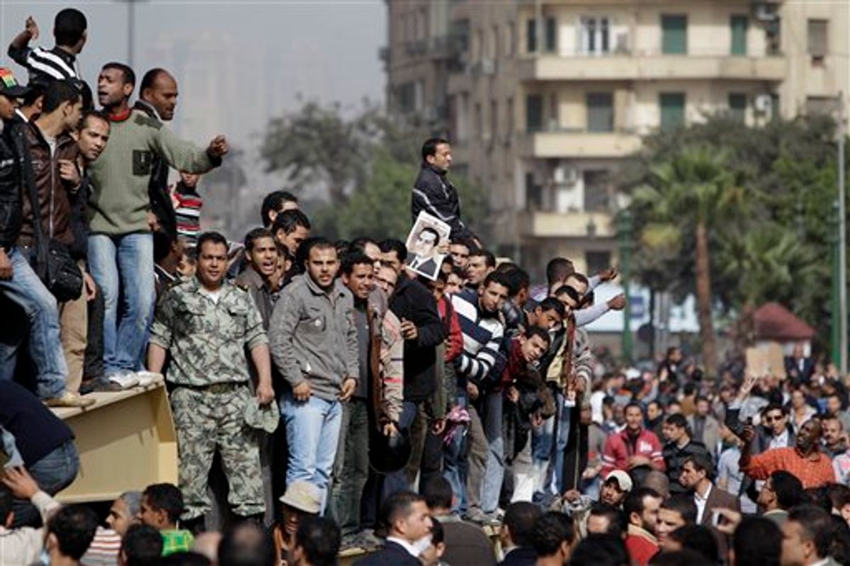 Egyptian anti-government protesters climb atop an Egyptian army armored personnel carrier in Cairo, Egypt, Saturday, Jan. 29, 2011. (AP Photo/Ben Curtis) (AP)