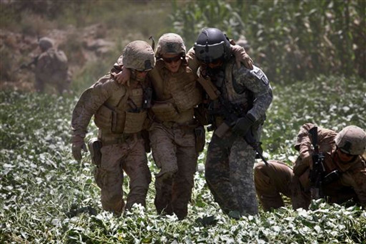 In this Sept. 2, 2010 photo, a U.S. Marine, left, and U.S. Amy Flight Medic Staff Sgt. Richard Jarrett, right, rush U.S. Marine Pfc. Justin Turner, center, of Flower Mound, Texas, who was wounded in an IED attack, across an irrigated field deep with mud to a waiting U.S. Army Task Force Shadow medevac helicopter, west of Lashkar Gah, in southern Afghanistan. Aeromedical teams with the 101st Airborne's Task Force Destiny provide the fast medical evacuation of those wounded throughout southern Afghanistan. (AP Photo/Brennan Linsley) (AP)