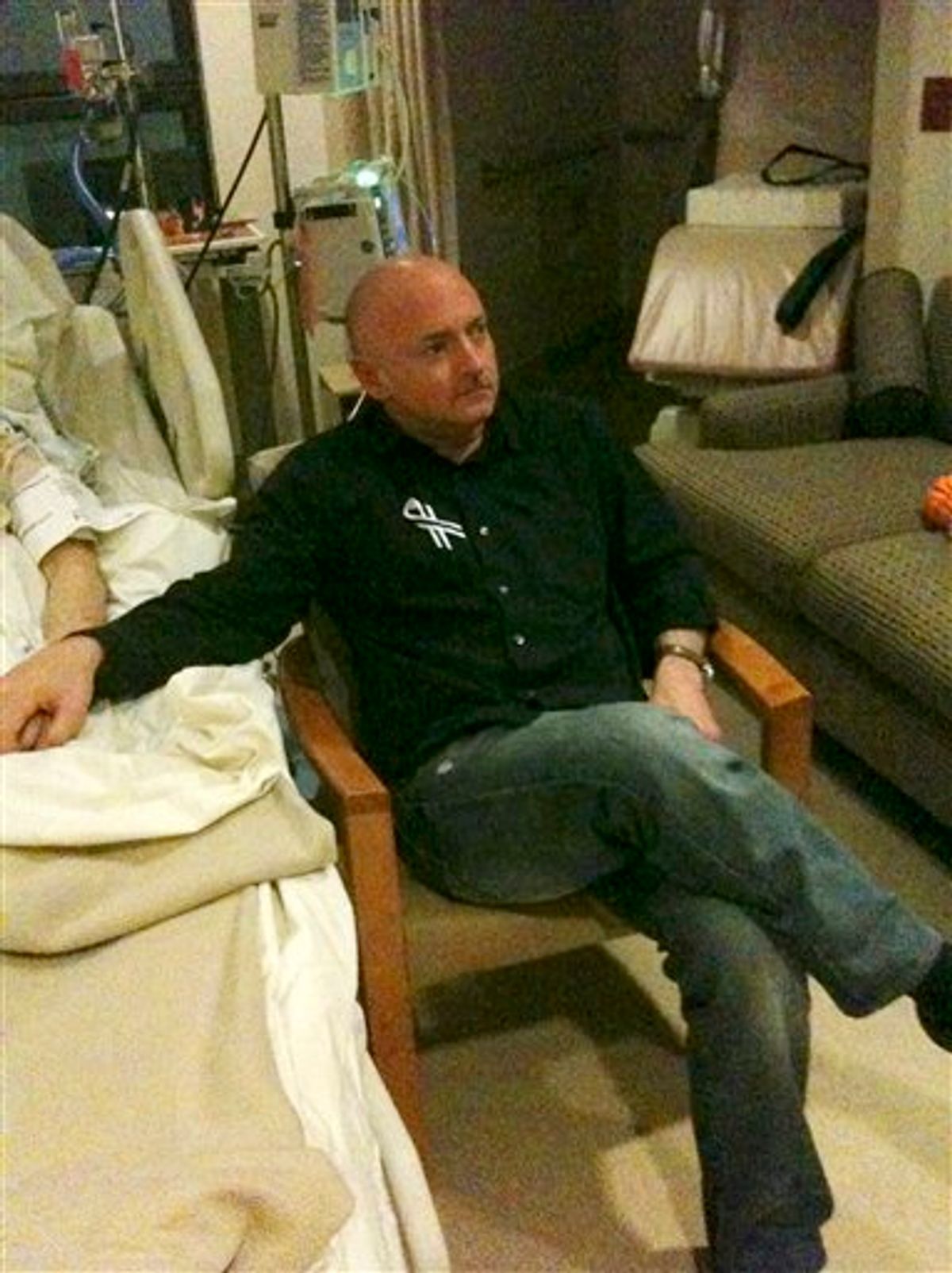 A photo released by the office of U.S. Rep. Gabrielle Giffords shows Rep. Giffords husband Mark Kelly watching the State of The Union speech while holding his wife's hand in her hospital room in Houston Tuesday  Jan. 25, 2010.  (AP Photo) (AP)