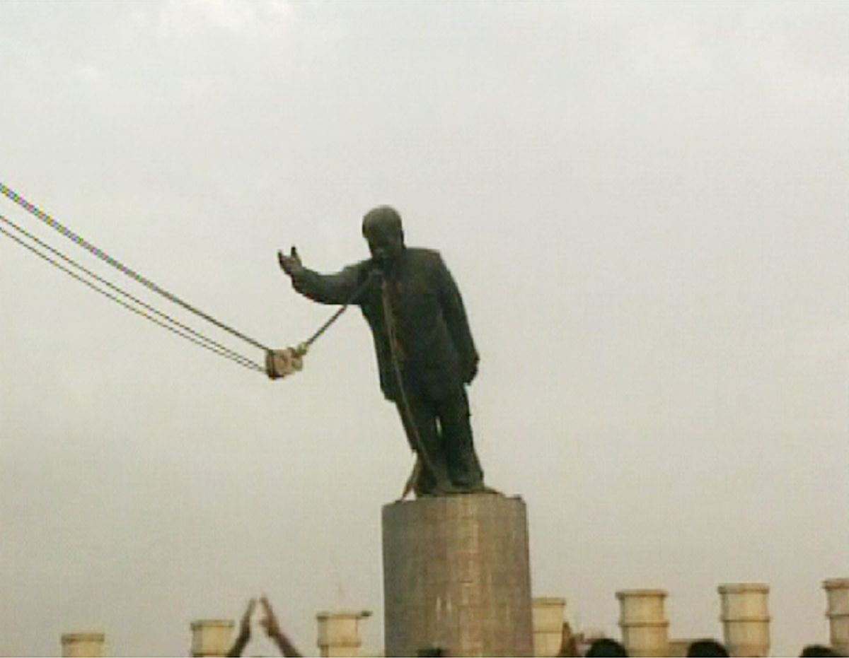 People gather Wednesday, April 9, 2003, in this image from video, as U.S. Marines help bring down a giant statue of Saddam Hussein in a square in central Baghdad. (AP Photo/APTN) (Associated Press)
