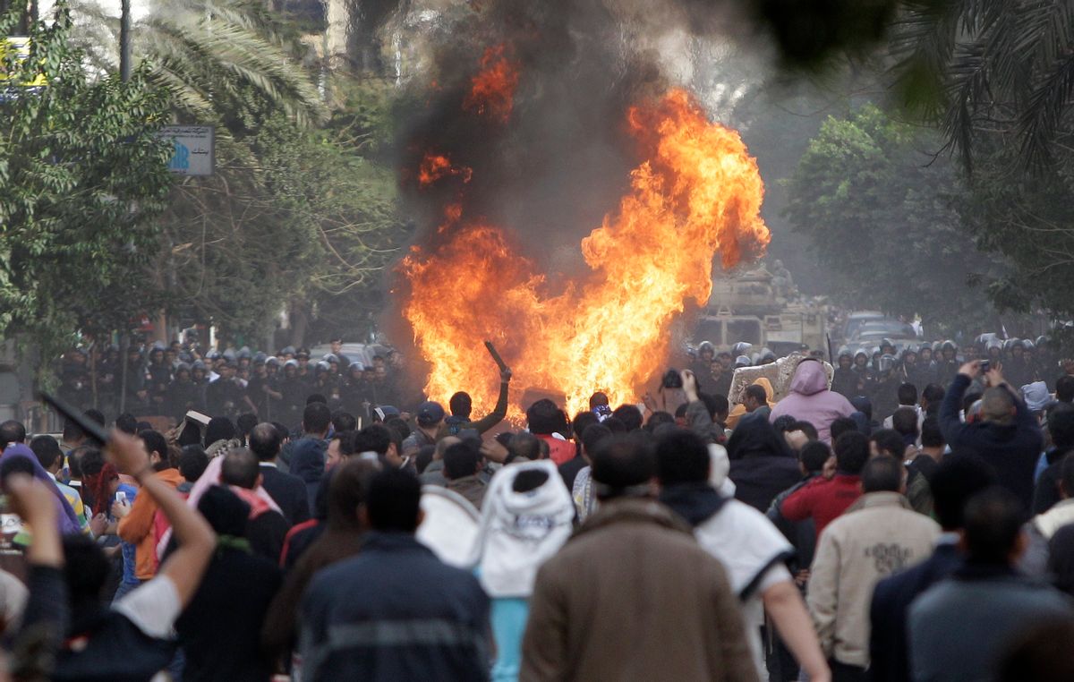 Protesters throw firebombs at riot police after police shot at protesters accompanying the funeral procession of an anti-government protester killed yesterday, in a street near Tahrir square in downtown Cairo, Egypt, Saturday, Jan. 29, 2011. Thousands of  protesters returned to Cairo's central Tahrir Square, chanting slogans against Egyptian President Hosni Mubarak and demanding his departure. (AP Photo/Ben Curtis) (Associated Press)