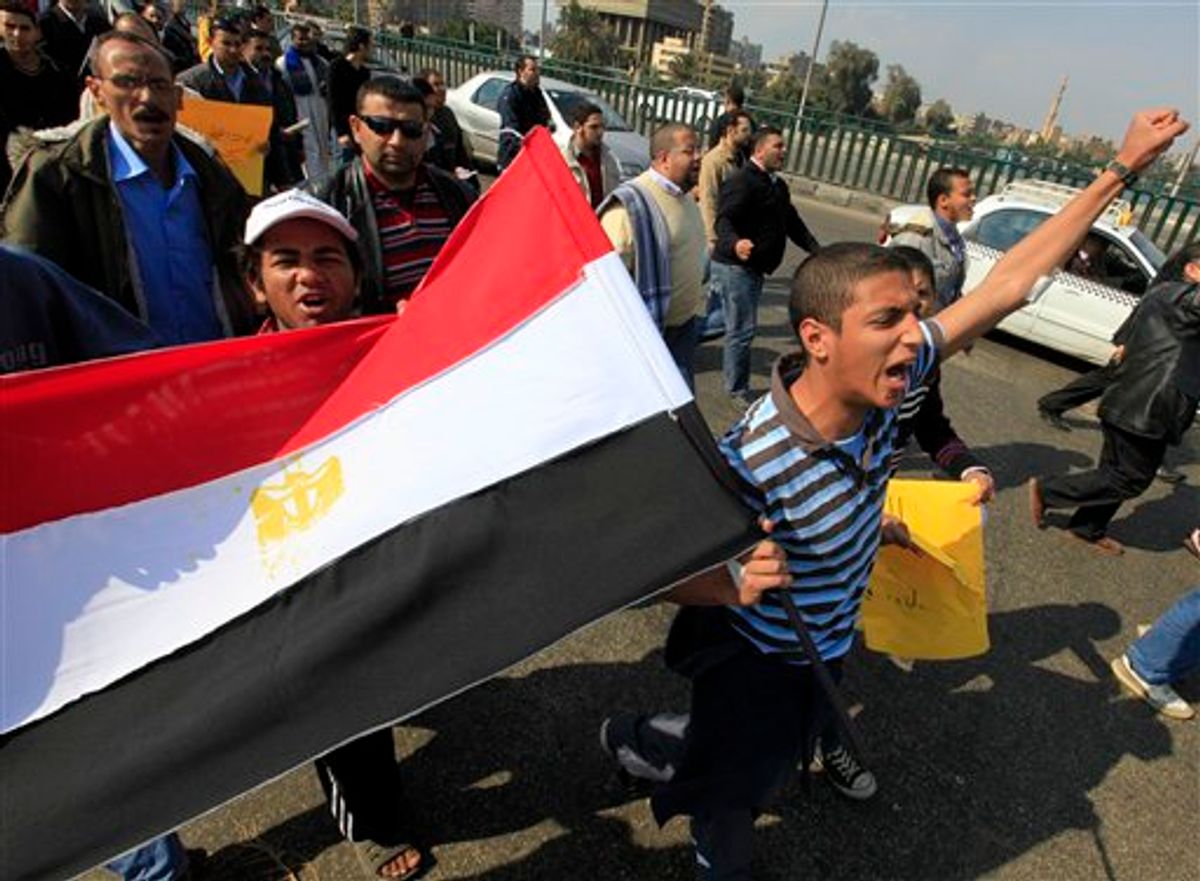 Anti-government protesters wave an Egyptian flag during a march in Cairo, Egypt, Friday, Feb. 11, 2011. Egypt's powerful military backed President Hosni Mubarak's plan to stay in office until September elections, but massive crowds outraged by his refusal to step down packed squares in Egypt's two biggest cities Cairo and Alexandria on Friday. (AP Photo/Amr Nabil) (AP)