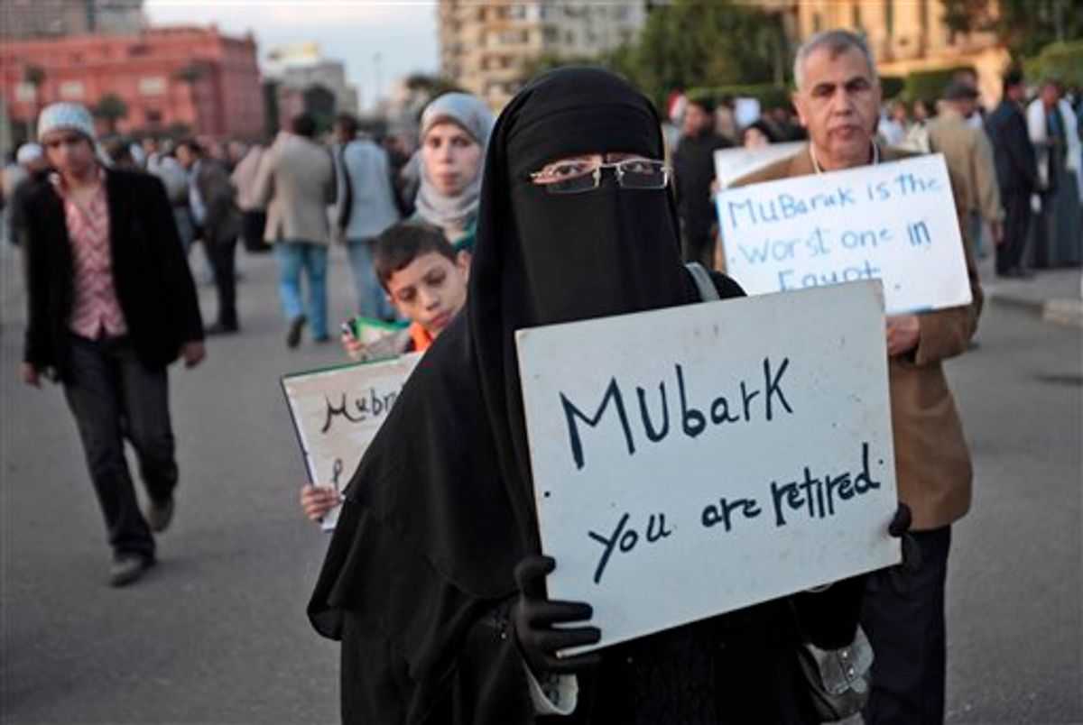 A woman carrying a placard referring to Egyptian President Hosni Mubarak attends a demonstration by anti-government protesters in Cairo's Tahrir Square, Egypt, Monday, Jan. 31, 2011. A coalition of opposition groups called for a million people to take to Cairo's streets Tuesday to demand the removal of Mubarak. AP Photo/Lefteris Pitarakis) (AP)