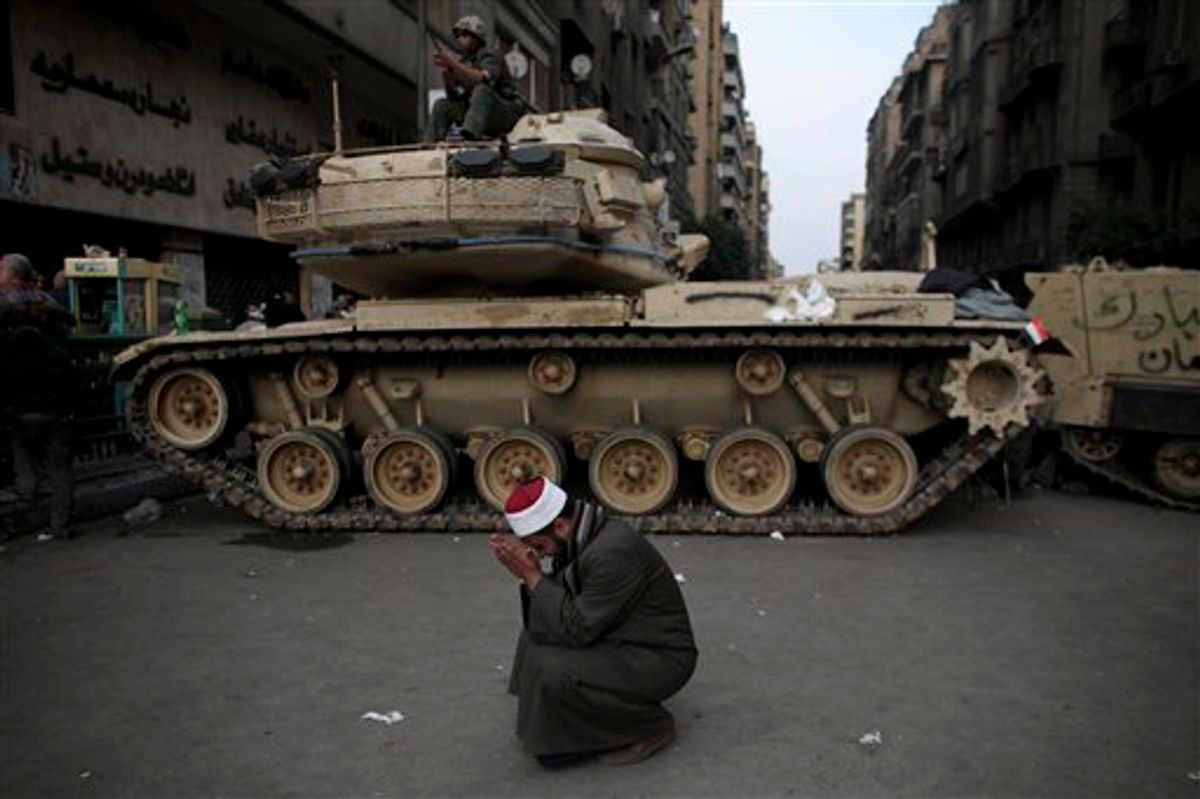 An Egyptian Muslim cleric cries in front of on army tank in Tahrir, or Liberation square, in Cairo, Egypt, Wednesday, Feb. 2, 2011. Several thousand supporters of President Hosni Mubarak, including some riding horses and camels and wielding whips, clashed with anti-government protesters Wednesday as Egypt's upheaval took a dangerous new turn. (AP Photo/Tara Todras-Whitehill) (AP)