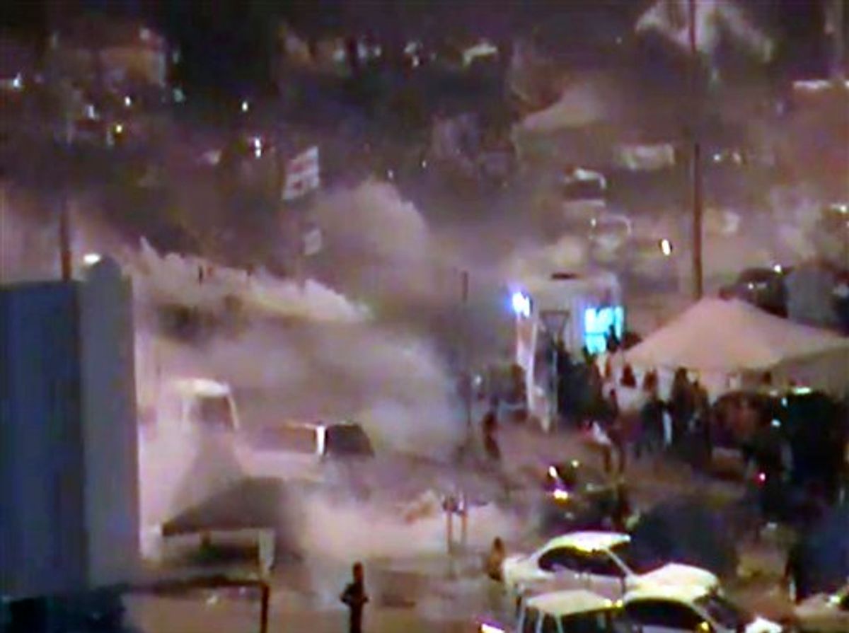 In this image from video riot police firing tear gas and wielding clubs storm Pearl Square occupied by anti-government protesters before dawn Thursday, Feb. 17, 2011 driving out demonstrators and destroying a makeshift encampment that had become the hub for demands to bring sweeping political changes to the kingdom. (AP Photo/Tony Mitchell, HO) (AP)