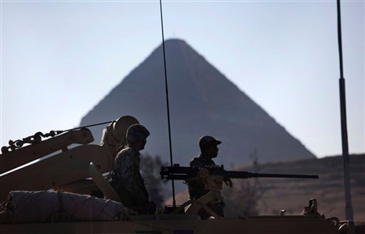 Egyptian Army soldiers are seen on top of an APC vehicle near the pyramids, in Giza, Egypt, Monday, Jan. 31, 2011. The pyramids are closed to tourists.  A coalition of opposition groups called for a million people to take to Cairo's streets Tuesday to demand the removal of President Hosni Mubarak (AP Photo/Emilio Morenatti) (AP)