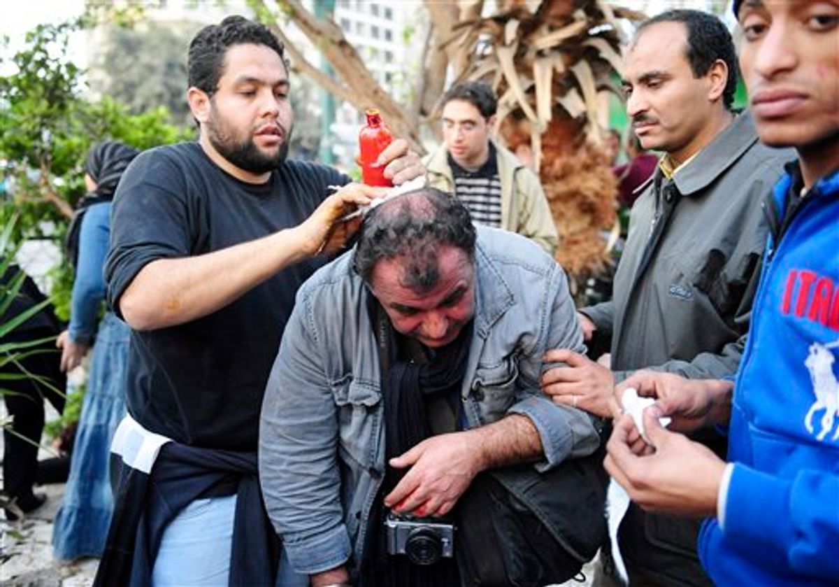 French photojournalist from SIPA Press agency Alfred Yaghobzadeh is being treated by anti-government protestors after being wounded during clashes between pro-government supporters and anti-government protestors, in Cairo's central Tahrir Square, Wednesday Feb. 2, 2011 in Cairo, Egypt.  The Egyptian military has started Thursday Feb.3, 2011 rounding up journalists, possibly for their own protection, after they came under attack from supporters of President Hosni Mubarak who have been attacking anti-government protesters. (AP Photo) (AP)