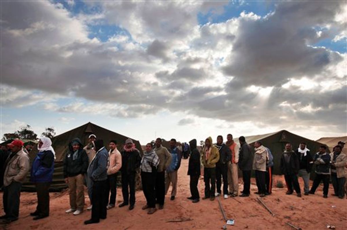 Egyptians, who used to work in Libya, and fled the unrest in the country, wait for their breakfast in a makeshift refugee camp set up by the Tunisian army, at  the Tunisia-Libyan border, in Ras Ajdir, Tunisia,  Friday, Feb. 25, 2011. (AP Photo/Lefteris Pitarakis)  (AP)