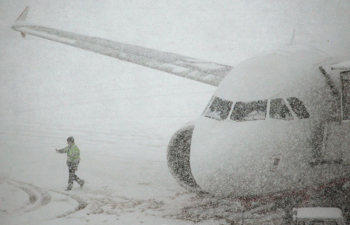 A worker walks past a plane parked on the snow covered tarmac of Zurich airport in Kloten after the region was hit by strong snow falls, December 17, 2010. REUTERS/Christian Hartmann (SWITZERLAND - Tags: ENVIRONMENT TRANSPORT) (Reuters)
