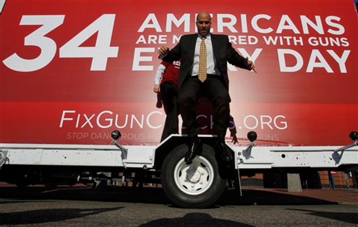 Newark Mayor Cory Booker leaps from the wheel cover of a mobile billboard after taking photos on it during part of the FixGunChecks.org Truck tour stop, Wednesday, Feb. 16, 2011, in Newark, N.J. The truck will be driven across the nation as part of the Mayors Against Illegal Guns which was launched by New York City Mayor Michael R. Bloomberg Wednesday. Its purpose will be to draw public attention to the deadly problems in the nations gun background check system. (AP Photo/Julio Cortez)   (AP)