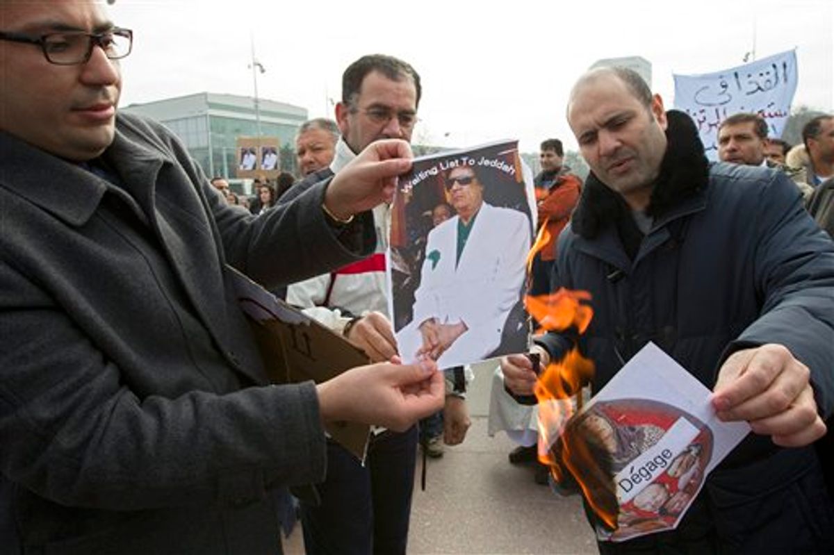 Protesters burn photos of Libyan leader Moammar Ghaddafi during a demonstration to support the Libyan people, on Place des Nations in front of the European headquarters of the United Nations, in Geneva, Switzerland, Saturday, Feb. 19, 2011. (AP Photo/Keystone, Salvatore Di Nolfi) (AP)