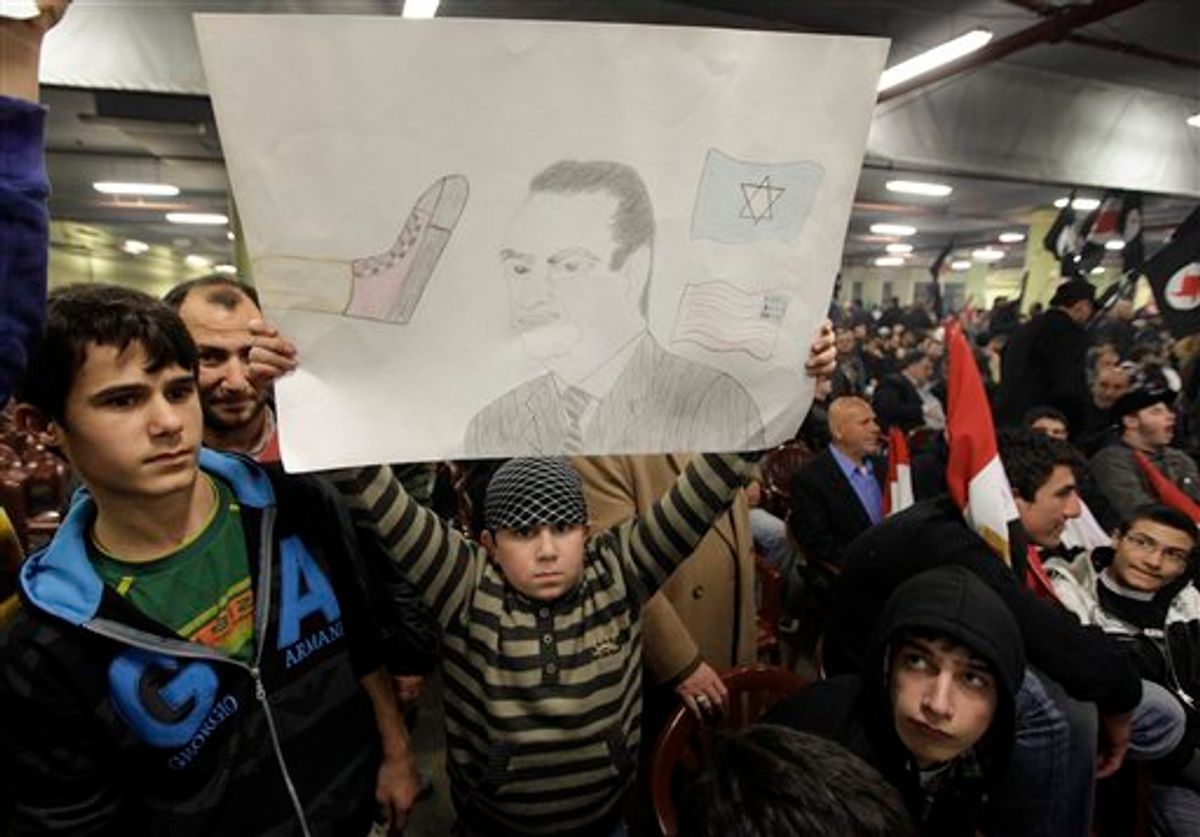 A youth holds a drawing depicting Egyptian President Hosni Mubarak during a speech by Hezbollah leader Hassan Nasrallah at a ceremony called for by Lebanese anti-American groups to support anti-government protesters in Egypt, in Beirut, Lebanon, Monday, Feb. 7, 2011. Speaking on a screen Nasrallah said the Egyptian uprising will change the Mideast for generations to come. (AP Photo/Bilal Hussein) (AP)
